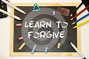 Text Learn to Forgive written with golden letters on a red heart