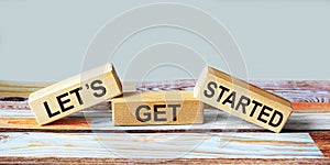 Text Let`s get started on wooden blocks and colored backgroundl photo