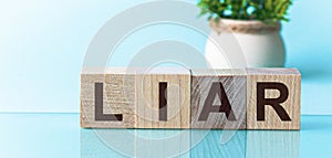 Text of LIAR on wooden cubes, blu background