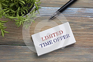 Text Limited time offer on white paper book and office supplies wood desk. Business concept