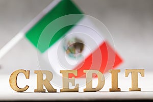 Text made of wooden letters and Mexican flag on an abstract background, a concept on the theme of the debt burden of the people of