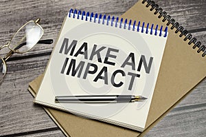 Text MAKE AN IMPACT on the white paper and glasses