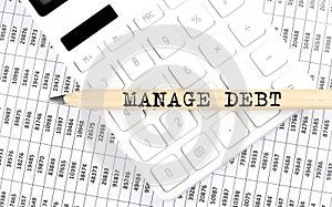 Text MANAGE DEBT on the wooden pencil on the calculator with chart