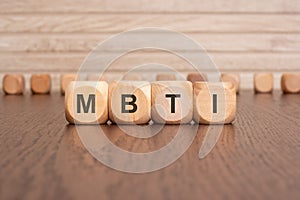 the text MBTI is written on wooden cubes on a brown background