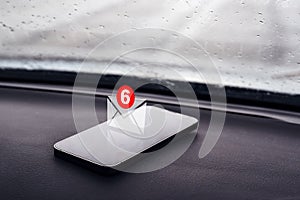 Text message notification icon on smartphone in car