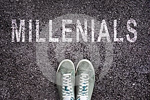 Text Millennials written on asphalt with shoes photo