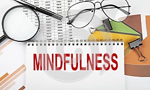Text MINDFULNESS on white paper notebook on the diagram. Business concept