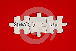Text on missing jigsaw puzzle - Speak up. With red background.