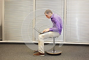 Text neck - man in slouching position working with computer photo