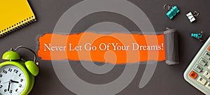 Text Never Let Go Of Your Dreams - appearing behind torn brown paper. Motivation quote