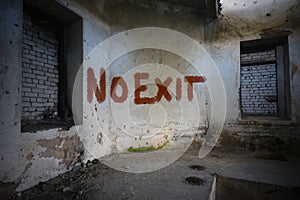 Text no exit on the dirty old wall in an abandoned ruined house