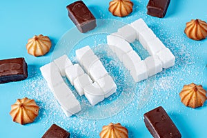 Text No is lined with sugar cubes with sweets and cookies. Harm to the health of sweet and rejection of sucrose