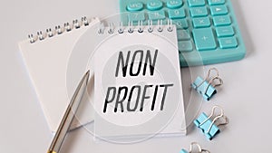 Text NON PROFIT on white keyboard stickers.glasses notepad on white background. Accounting concept