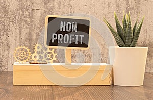 Text NON PROFIT on white keyboard stickers. glasses notepad on wooden background. Accounting concept