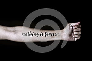 Text nothing is forever in a forearm