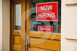 The Text Now Hiring Sticker Attached On Door photo