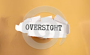 text Oversight on wooden block