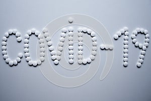 Text phrase Covid-19 sign concept made from white tablets