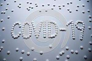 Text phrase Covid-19 sign concept made from white tablets