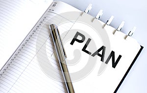 Text PLAN on the short note texture background with pen