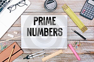 Text Prime Numbers in light box on office desk flat lay