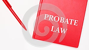 The text PROBATE LAW is written on a red notepad near a red pen on a white table in the office. Business concept