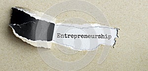 The text Ready to get ENTERPRENEURSHIP behind torn brown paper