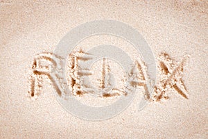 Text Relax writing on sand at the beach