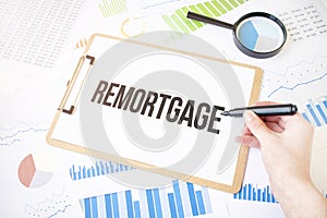 Text remortgage on white paper sheet and marker on businessman hand on the diagram. Business concept