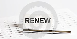 Text RENEW on stickers,pen on the background of documents. Financial bookkeeping, Accounting Concept. Top view