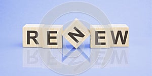 text RENEW on wooden cubes. bright blue surface