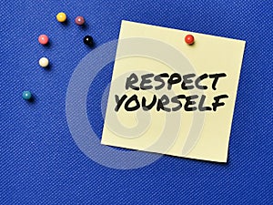 Text RESPECT YOURSELF written on yellow paper note with pin board over blue background.
