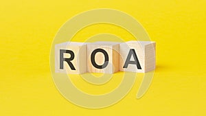 text roa on wood blocks, yellow background