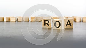 text ROA on wooden cubes. abbreviation of \'Return on Assets\'. square wood blocks. top view, flat lay