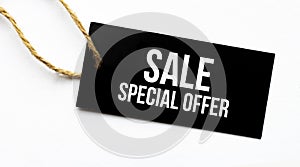 Text SALE SPECIAL OFFER on a black tag on a white paper background
