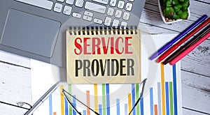 Text SERVICE PROVIDER on notepad with office tools, pen and laptop