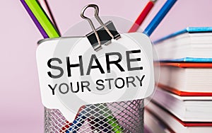 Text Share your story on a white sticker with office stationery background. Flat lay on business, finance and development concept