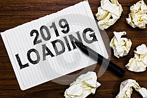 Text sign showing 2019 Loading. Conceptual photo Advertising the upcoming year Forecasting the future event Marker over notebook c