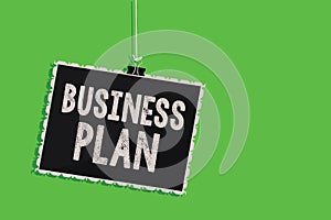 Text sign showing Business Plan. Conceptual photo Structural Strategy Goals and Objectives Financial Projections Hanging blackboar