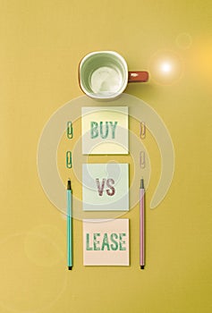 Text sign showing Buy Vs Lease. Conceptual photo Own something versus borrow it Advantages Disadvantages Coffee cup