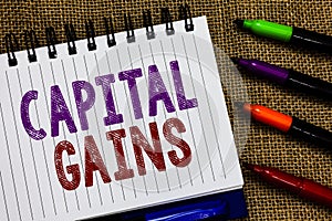 Text sign showing Capital Gains. Conceptual photo Bonds Shares Stocks Profit Income Tax Investment Funds Open spiral notebook page