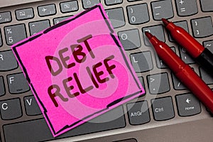 Text sign showing Debt Relief. Conceptual photo partial or total remission of it especially those by countries Pink paper keyboard