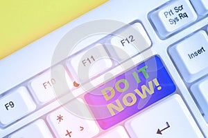 Text sign showing Do It Now. Conceptual photo not hesitate and start working or doing stuff right away White pc keyboard
