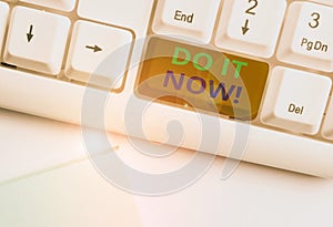 Text sign showing Do It Now. Conceptual photo not hesitate and start working or doing stuff right away White pc keyboard with