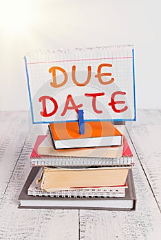 Text sign showing Due Date. Conceptual photo the day or date by which something is supposed to be done or paid pile