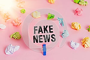 Text sign showing Fake News. Conceptual photo Giving information to showing that is not true by the media Colored crumpled papers