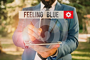 Text sign showing Feeling Blue. Conceptual photo Feeling of desperation because of sadness or missing someone Businessman in blue