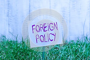 Text sign showing Foreign Policy. Conceptual photo a government strategy in dealing with other nations Plain empty paper attached