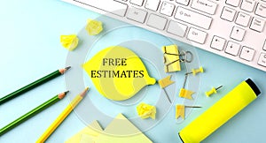 Text sign showing FREE ESTIMATES with office tools and keyboard on blue background