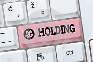 Text sign showing Holding. Internet Concept stocks property and other financial assets in someone s is possession Typing